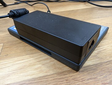 The 120 W AC adapter is large (14.5 x 6.4 x 3 cm) relative to the small mini PC