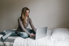 Working on your bed can blur the lines between your professional and personal lives. (Image via Andrew Neel on Unsplash)