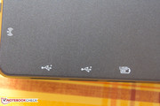 On the smooth rubbery surface of the palm resting area, the ports on the sides of the notebook are labeled.