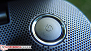 The svelte power button embedded in the perforated speaker cover