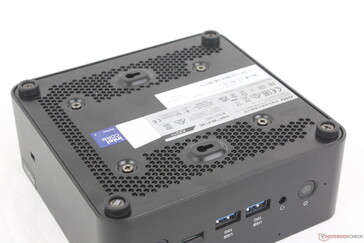 Bottom side showing ventilation grilles, VESA screws, and rubber feet