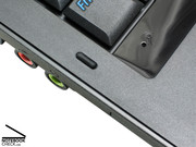 The microphone is in the glossy moulding below the keyboard.