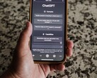 A hand holding a smartphone with the ChatGPT interface open