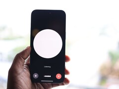 A hand holding a smartphone with a voice assistant interface on the screen
