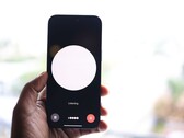 A hand holding a smartphone with a voice assistant interface on the screen