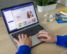 Hands typing on a laptop showing an online shop.