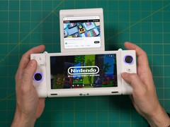 Russ from Retro Game Corps holding the OneXSugar Sugar 1 dual-screen handheld gaming console, with a Nintendo game on the main screen and a YouTube video playing on the secondary display. (Image Source: Retro Game Corps on YouTube)