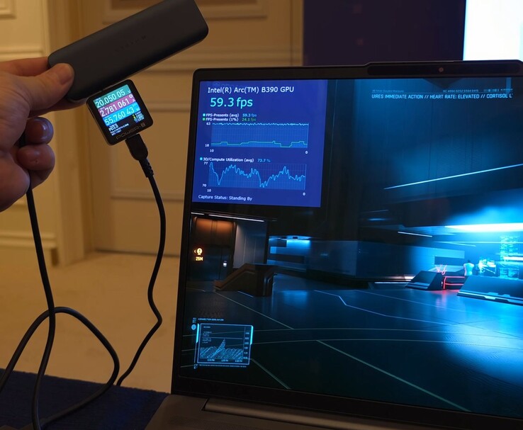 Intel Panther Lake reference laptop running a game with Intel Arc B390 iGPU performance overlay visible, while an external watt meter measures power consumption during gameplay (Image source: ETA Prime via YouTube)