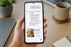 A hand holding a smartphone showing an AI answer with a sponsored ad below it