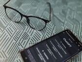 Smartphone with the ChatGPT app open next to a pair of glasses on a patterned surface