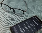 Smartphone with the ChatGPT app open next to a pair of glasses on a patterned surface