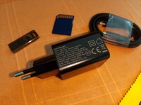 The charger and cable, an SD card and USB pen drive for scale (Image source: Sergey Tarasov - Notebookcheck)