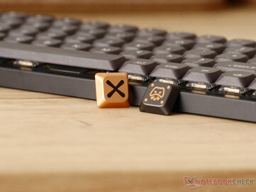 Two metal accent keycaps included with the Magi65 Pro.