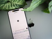 Smartphone with the ChatGPT app open, resting on a laptop next to plant leaves