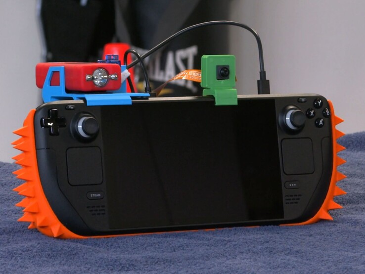 A Steam Deck fitted with a DIY security system consisting of spikes, a camera and a stun gun.