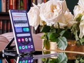 A Samsung Galaxy S25 Ultra standing upright on a table, an open website visible on the display