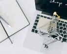 Miniature shopping cart on a laptop keyboard, with Shop now on the screen