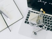 Miniature shopping cart on a laptop keyboard, with Shop now on the screen