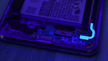 iFixit's funky purple powder (brighter spots under this light) is visible within the Z Flip during its teardown... (Source: YouTube)