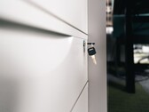 A key sitting in the lock of a closed wooden drawer