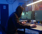 Generic hacker at a dual-monitor workstation executing a supply chain attack.