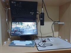 A Reddit user's gaming laptop mounted upside down in a wooden shelf, connected to an external keyboard, mouse, and microphone. (Image source: Reddit/u/YusufK80)