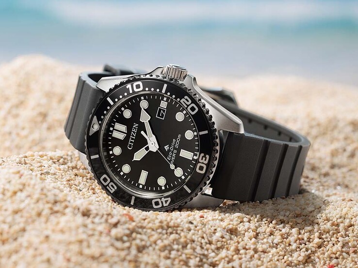 Citizen Promaster Marine BN0266-07E with a black dial, black bezel, and black strap resting on sand.
