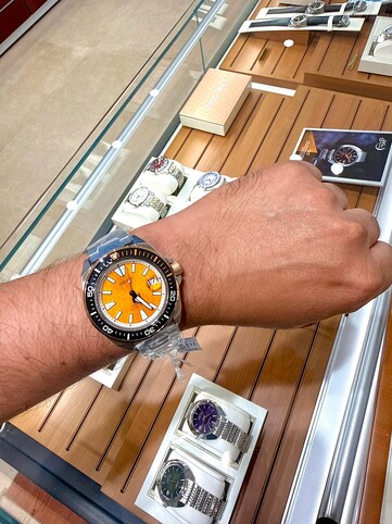 Seiko Prospex HBB005K1 tiger-inspired diver worn on the wrist, showing its amber textured dial, black bezel with orange accents, and stainless steel case and bracelet.