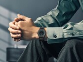 Citizen Eco-Drive One AR5065-54W on a wrist, featuring a forest green and black dial, rose gold accents, and an ultra-thin black-coated bracelet.