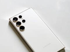 White Samsung Galaxy smartphone with four rear cameras on a light surface