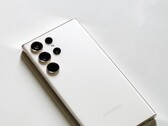 White Samsung Galaxy smartphone with four rear cameras on a light surface