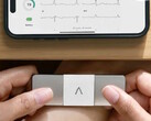 An AliveCor KardiaMobile 6L Max held by both hands to measure a person's ECG. (Image source: AliveCor)