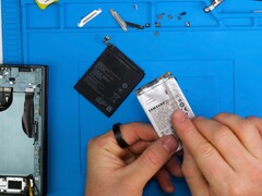 Galaxy Z TriFold's battery and Honor's silicon carbon battery (black) with a torn down Galaxy Z TriFold on the left.