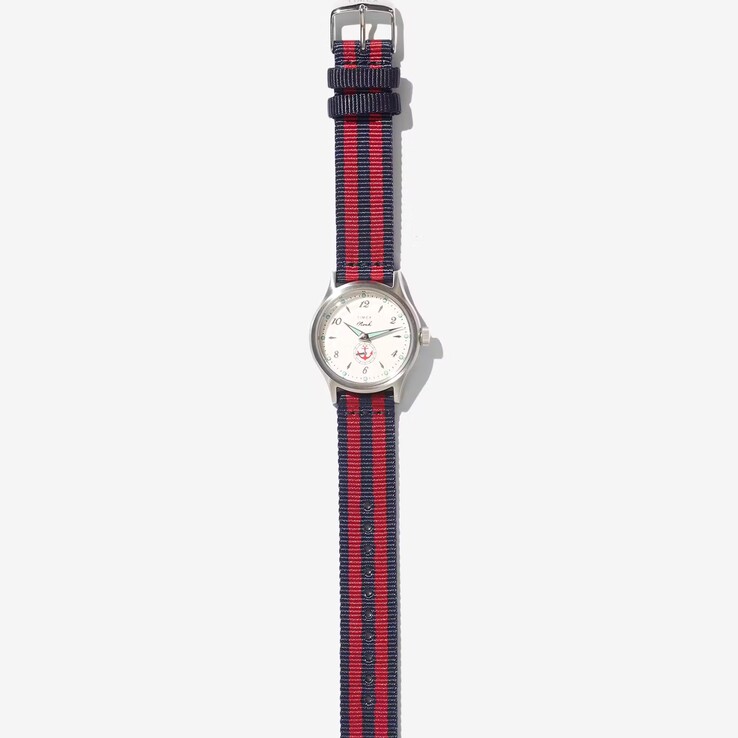 Noah x Timex MK1 Anchor watch with a silver-tone 36mm case, cream dial, anchor graphic, and navy-and-red striped fabric strap.