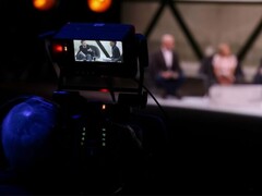 A photograph of a camera filming an interview