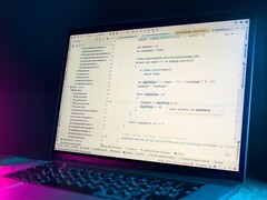 Laptop with a code editor open in a dark room