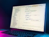 Laptop with a code editor open in a dark room