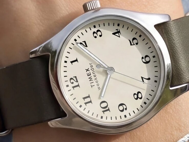 Timex Weekender New England TW2Y86600 with a silver-tone case and dark green leather strap viewed at an angle.