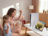 Woman and child playing PS5 game on portable monitor