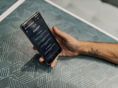 Hand holding a smartphone with the ChatGPT app open above a patterned table