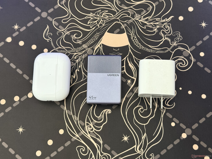 The Ugreen Nexode Air 45W Slim next to the AirPods Pro case and Apple 18W charger