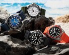 Four Citizen Promaster Marine dive watches in white, black, blue, and orange colorways displayed on rocks by the seaside.
