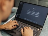 A person is typing on a laptop with the ChatGPT homepage open