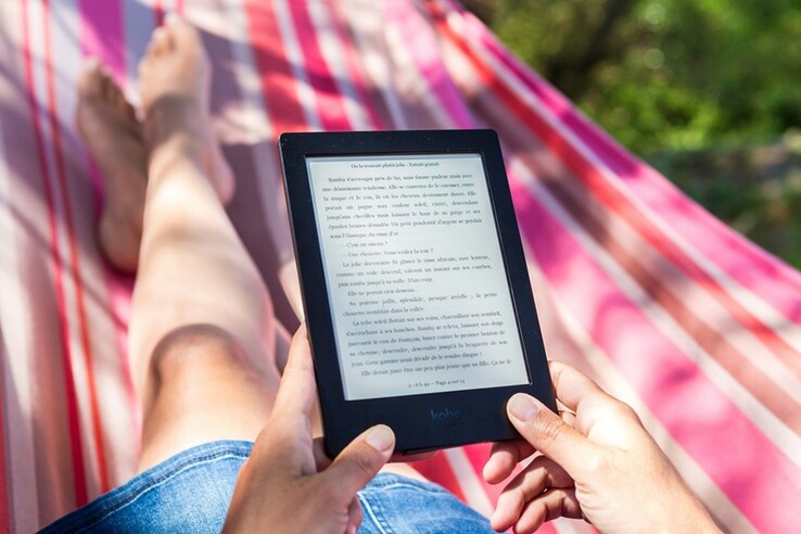 Kicking back with a Kindle—because nothing says "I'm busy relaxing" like getting lost in a good book under the sun. (Image Source: Perfecto Capucine - Unsplash)