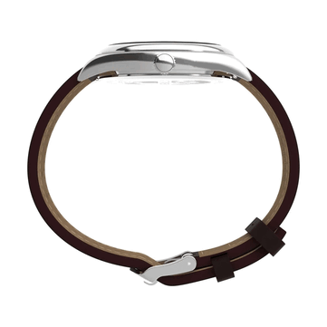 Side profile of the Timex Legacy Day and Date, highlighting its polished stainless steel case, ridged crown, curved lugs, and brown leather strap against a white background.