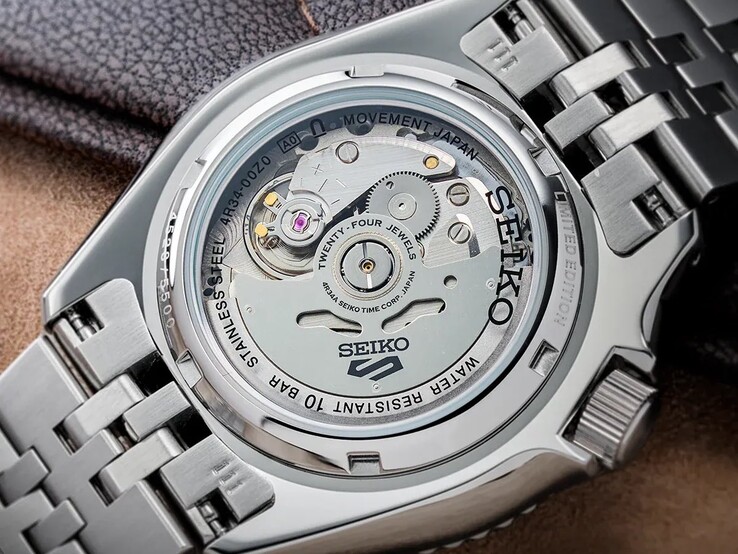 Close-up of the Seiko 5 Sports GMT HDB016’s exhibition caseback, revealing the automatic 4R34 movement inside its stainless steel case and the watch’s metal bracelet.