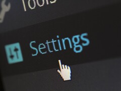 Close-up of a screen showing a Settings menu item and a mouse pointer