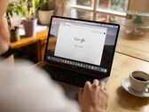 Person at a laptop with the Google homepage open, next to a cup of coffee