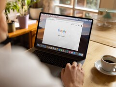 Person at a laptop with the Google homepage open, next to a cup of coffee