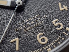 Close-up of the Timex Expedition Field Post Titanium’s textured black dial with Arabic numerals, luminous hands and markers, and date window.